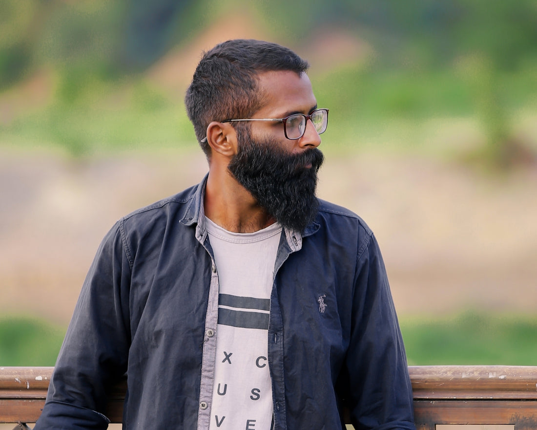 Man with beard and glasses looking away
